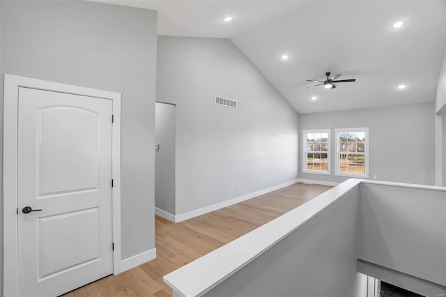 hall featuring high vaulted ceiling and light hardwood / wood-style floors