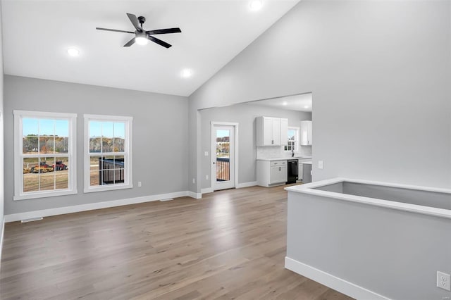 unfurnished living room with light hardwood / wood-style flooring, high vaulted ceiling, and ceiling fan