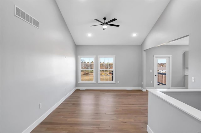 empty room featuring lofted ceiling, hardwood / wood-style floors, and ceiling fan