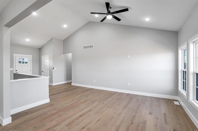 unfurnished living room with ceiling fan, lofted ceiling, and light wood-type flooring