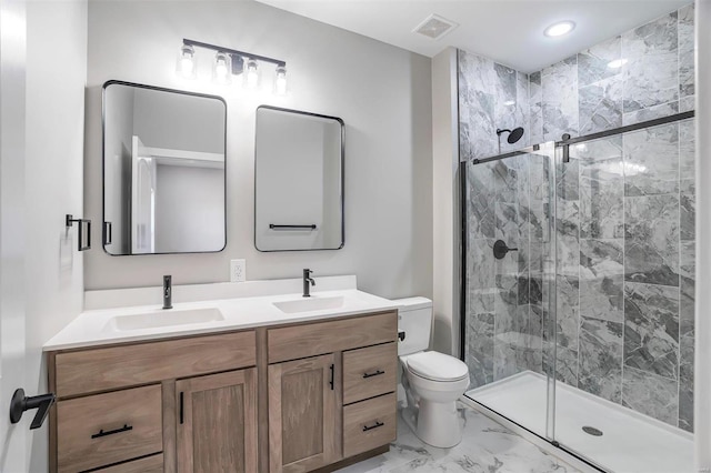 bathroom featuring vanity, toilet, and a shower with shower door