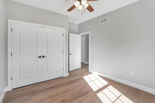 unfurnished bedroom with ceiling fan, a closet, and light hardwood / wood-style flooring