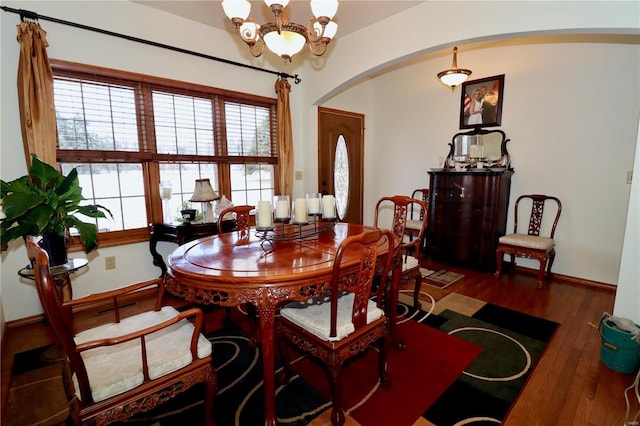 dining room with dark hardwood / wood-style floors and a chandelier