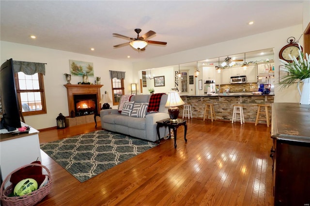 living room with hardwood / wood-style flooring and ceiling fan