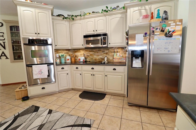 kitchen with backsplash, stainless steel appliances, and light tile patterned floors