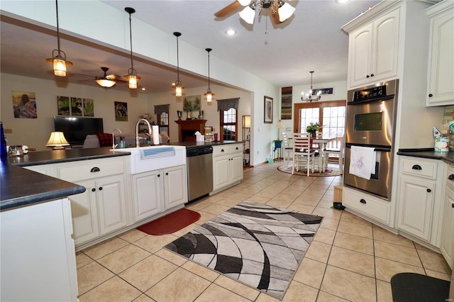 kitchen featuring stainless steel appliances, sink, hanging light fixtures, and light tile patterned floors