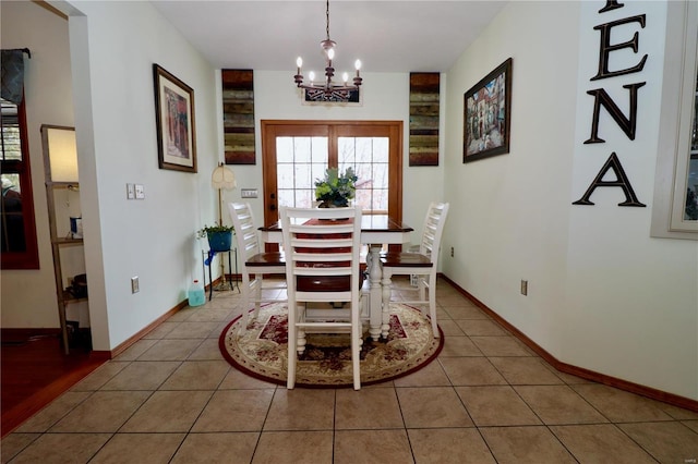 dining room with tile patterned floors and an inviting chandelier