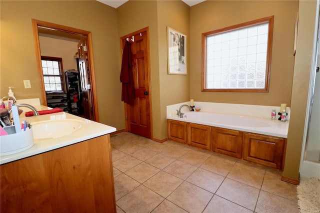 bathroom with tile patterned flooring, vanity, and a tub to relax in