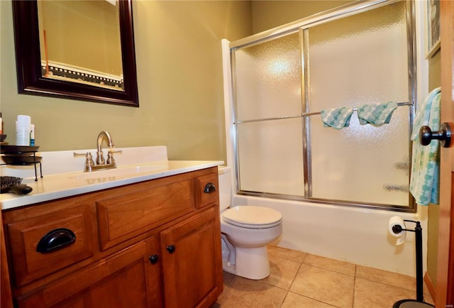 full bathroom with bath / shower combo with glass door, toilet, tile patterned floors, and vanity