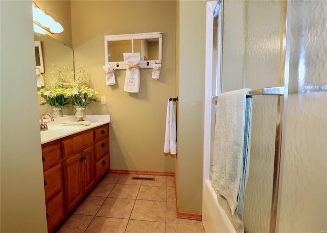 bathroom with tile patterned flooring, vanity, and bath / shower combo with glass door