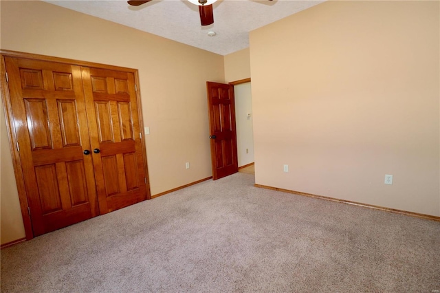 unfurnished bedroom with ceiling fan, light colored carpet, and a textured ceiling