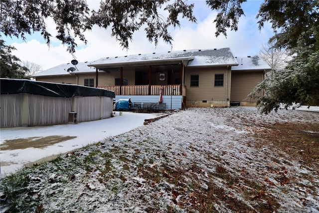 snow covered rear of property featuring a porch