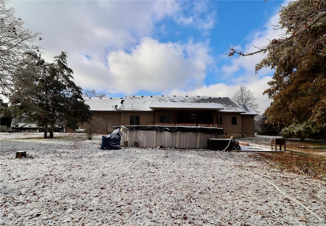 snow covered property with a covered pool