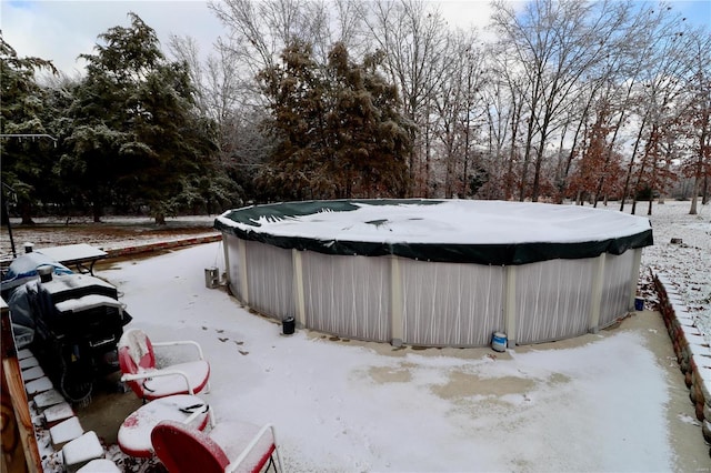 snowy yard featuring a covered pool