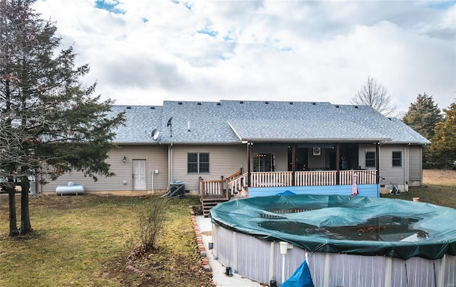 back of house featuring a pool side deck and a lawn