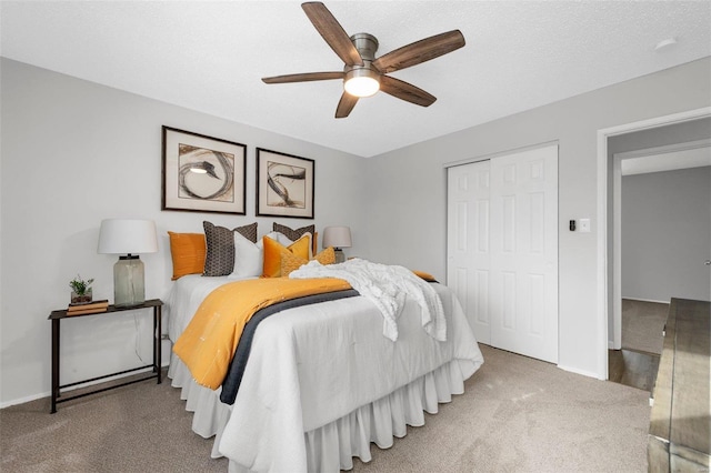 bedroom featuring a textured ceiling, carpet flooring, a closet, and ceiling fan