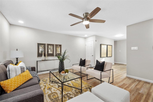 living room with light hardwood / wood-style floors and ceiling fan