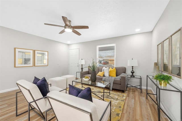 living room featuring ceiling fan and light wood-type flooring