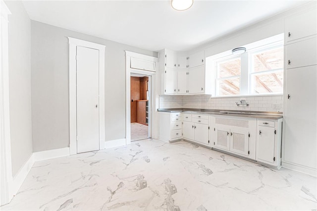 kitchen with sink, white cabinets, and tasteful backsplash