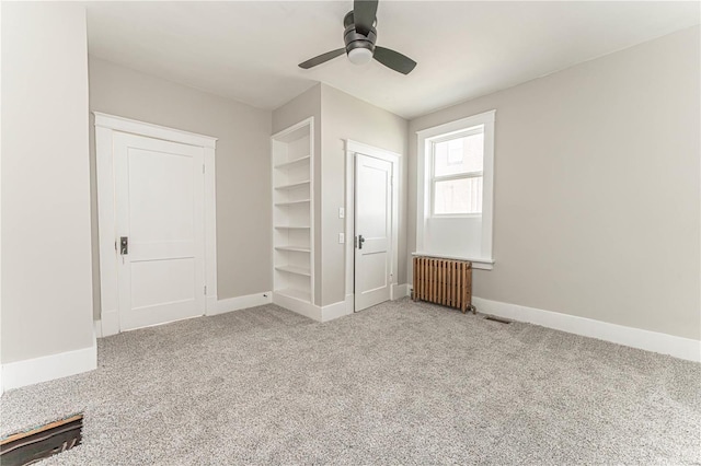 unfurnished bedroom featuring radiator, ceiling fan, and light colored carpet