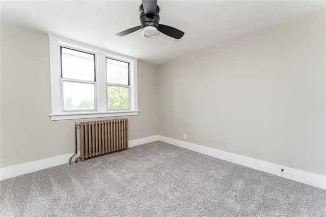 spare room with carpet flooring, ceiling fan, and radiator heating unit