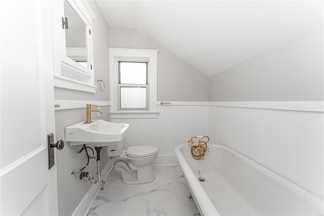 bathroom with lofted ceiling, toilet, and a tub