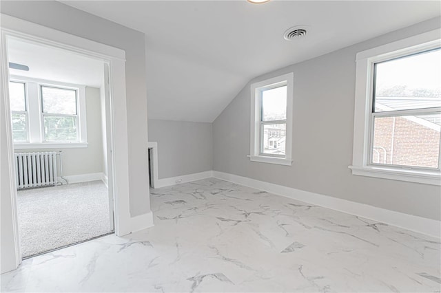 bonus room with radiator heating unit, a wealth of natural light, and vaulted ceiling