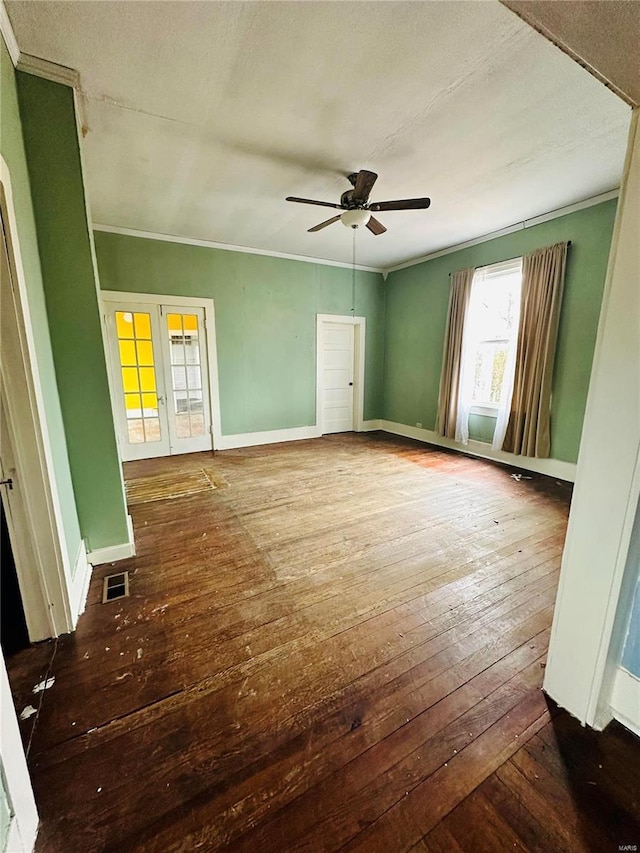 spare room featuring ceiling fan, crown molding, wood-type flooring, and french doors