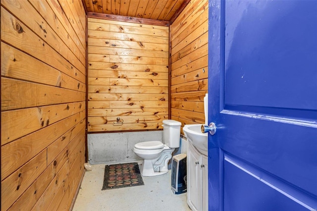 bathroom featuring wood walls, concrete floors, vanity, toilet, and wooden ceiling