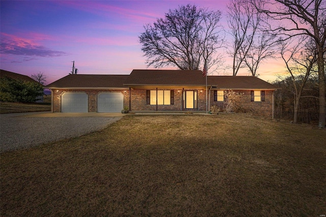 single story home with a garage and a yard