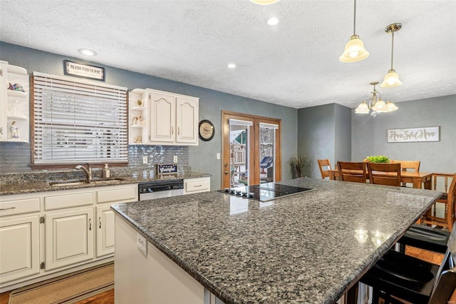 kitchen with hanging light fixtures, a center island, sink, and a breakfast bar area