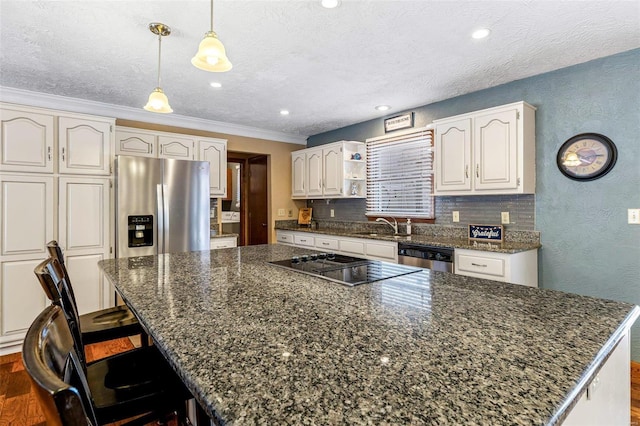 kitchen featuring stainless steel appliances, decorative light fixtures, a kitchen island, and white cabinets