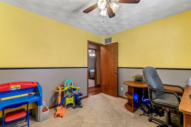 carpeted office featuring ceiling fan and a textured ceiling