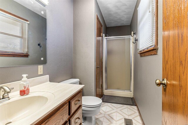 bathroom with vanity, an enclosed shower, and toilet