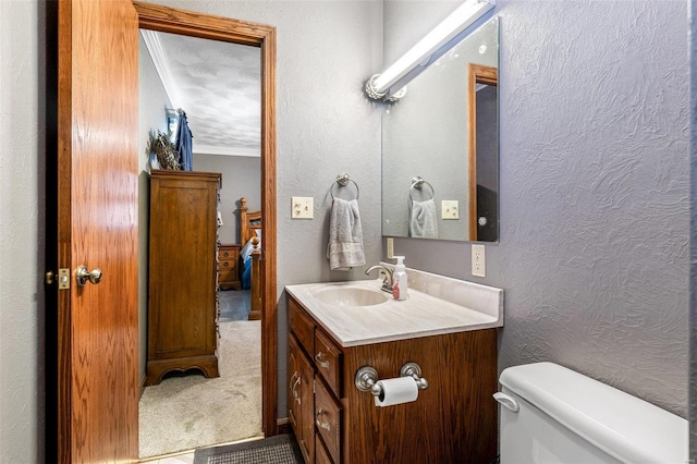 bathroom featuring crown molding, vanity, and toilet