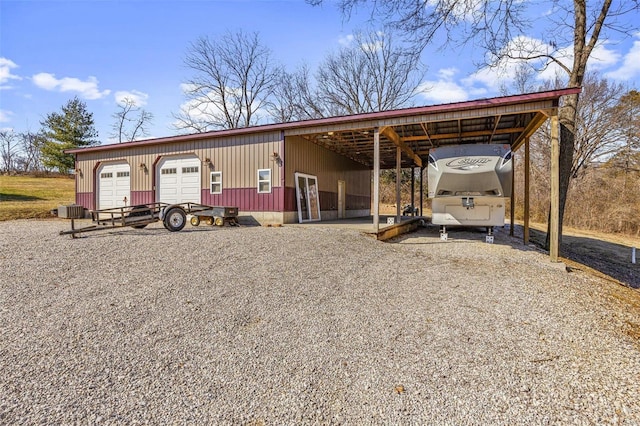 view of front of house with a garage, an outdoor structure, and central AC unit