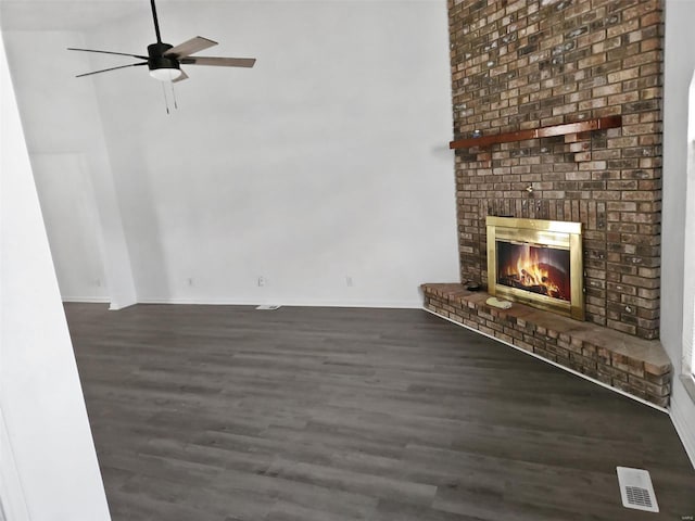 unfurnished living room with ceiling fan, a fireplace, and dark wood-type flooring