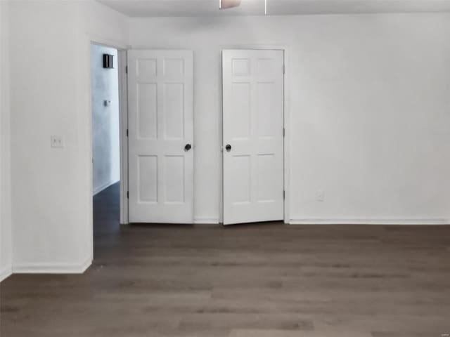 unfurnished bedroom with dark hardwood / wood-style flooring