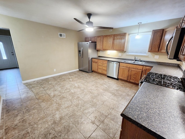 kitchen with ceiling fan, hanging light fixtures, sink, and appliances with stainless steel finishes