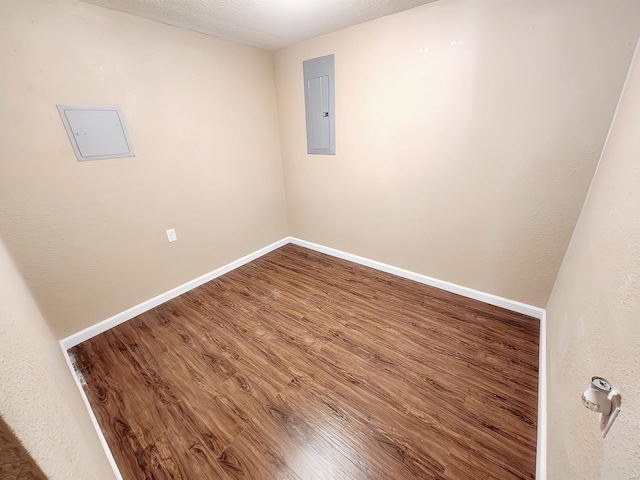 spare room with hardwood / wood-style floors and electric panel