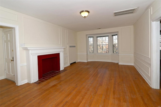 unfurnished living room featuring hardwood / wood-style flooring and a fireplace