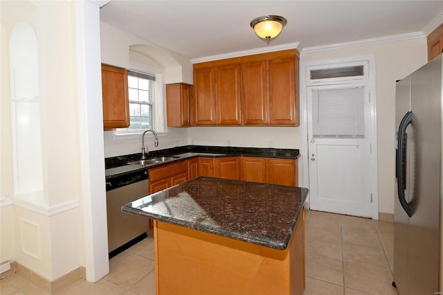 kitchen featuring crown molding, sink, a kitchen island, stainless steel appliances, and light tile patterned flooring