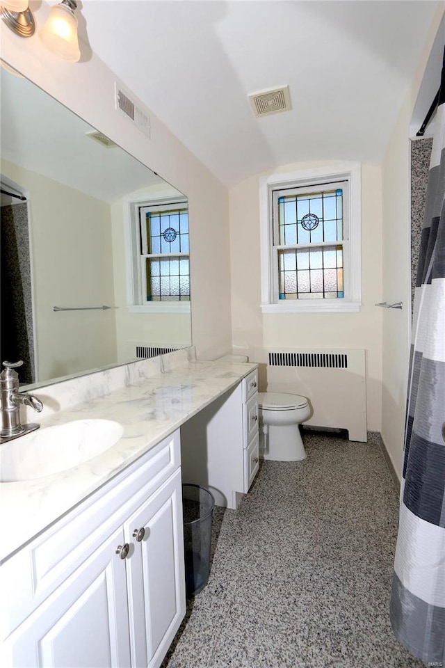 bathroom featuring toilet, radiator, and vanity