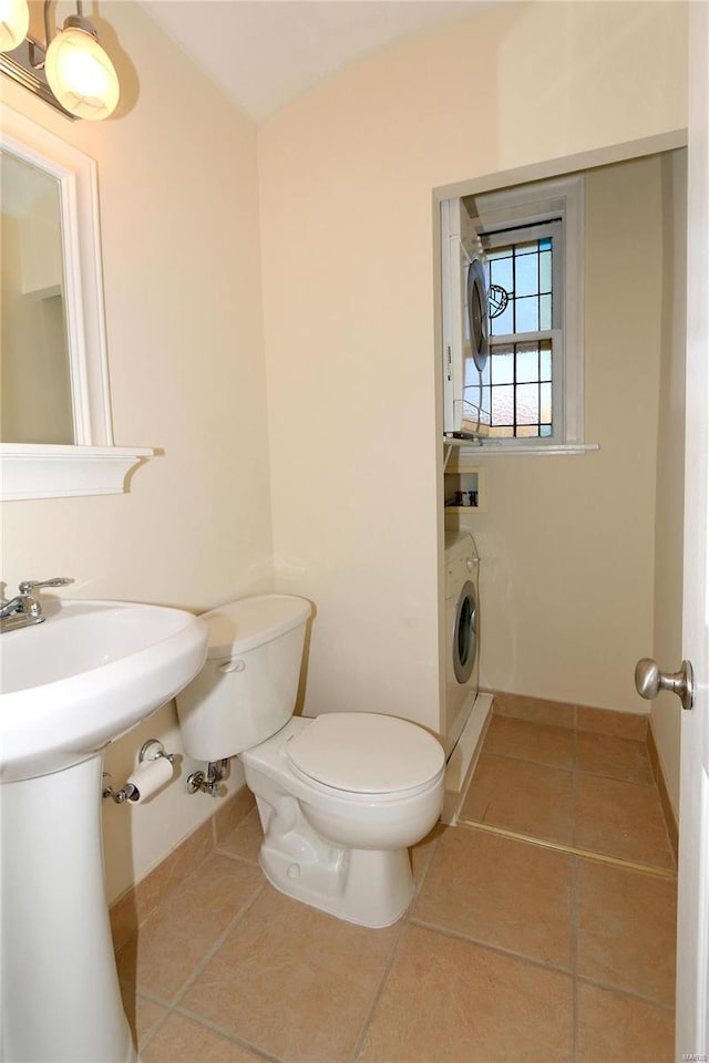 bathroom featuring tile patterned floors, washer / dryer, and toilet