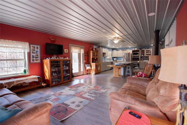 living room featuring ceiling fan, wooden ceiling, a healthy amount of sunlight, and hardwood / wood-style flooring