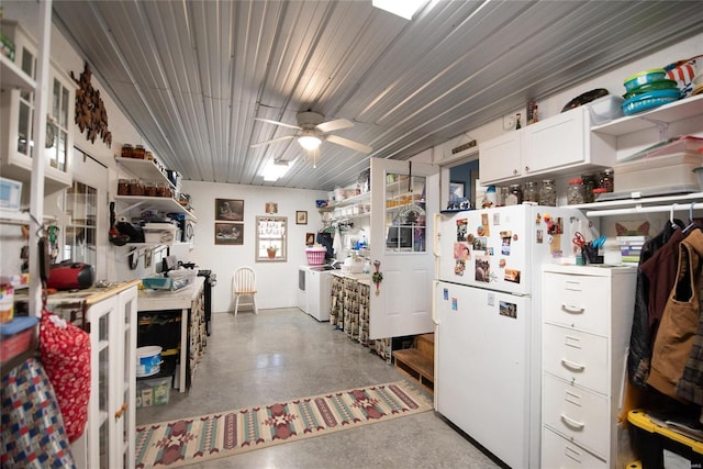 kitchen with ceiling fan, white fridge, washing machine and dryer, and white cabinetry