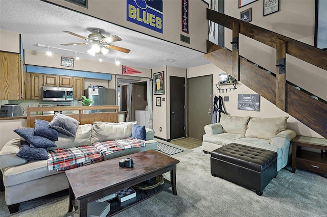 carpeted living room with ceiling fan, a textured ceiling, and rail lighting