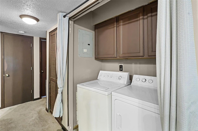 clothes washing area with light colored carpet, washer and dryer, electric panel, a textured ceiling, and cabinets