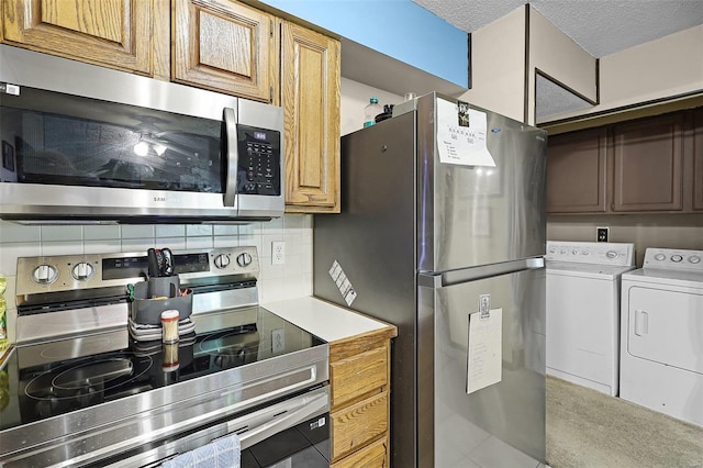 kitchen featuring tasteful backsplash, tile patterned floors, washing machine and dryer, stainless steel appliances, and a textured ceiling