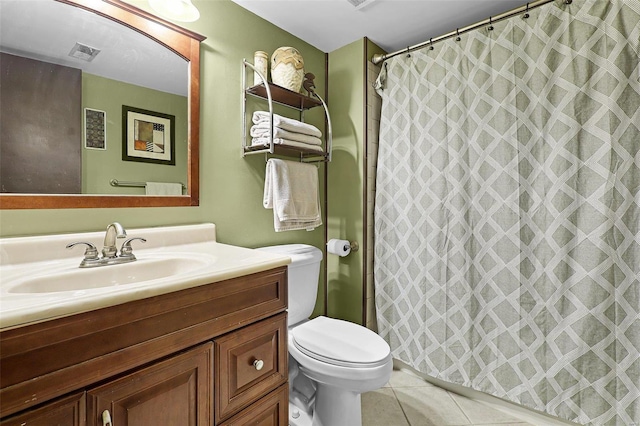 bathroom with toilet, vanity, walk in shower, and tile patterned flooring